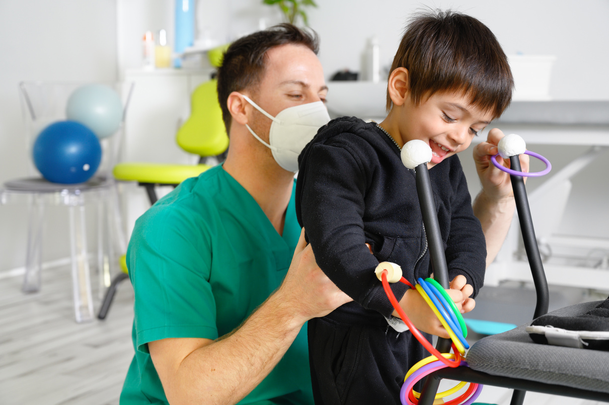 Child with Cerebral Palsy on Physiotherapy in a Children  Center. Boy with Disability Doing Exercises with Physiotherapists in Rehabitation Centre.